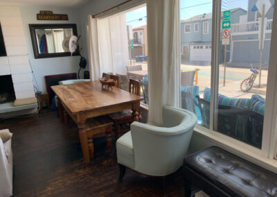 Dining table in front of large glass windows on a sunny beach day
